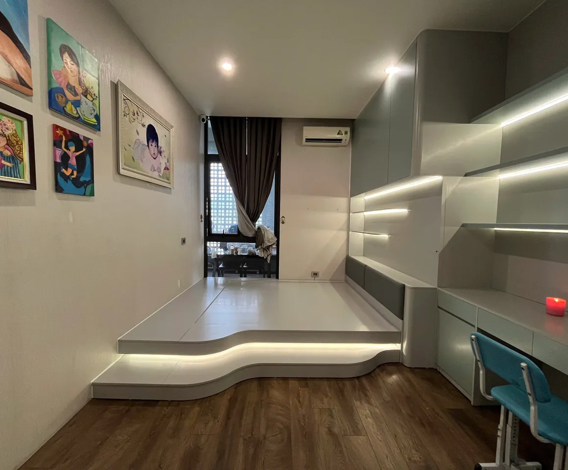Phòng ngủ chung cư với bục gỗ và bàn học